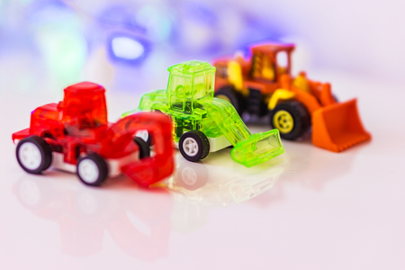 Toys red blured excavato, green loader and blured  loader, background bokeh. Concept motor skills.の写真素材