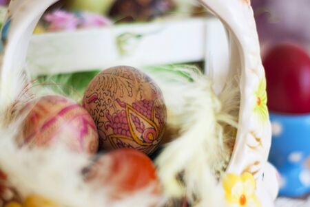 Basket painted Easter eggs, painted silk, decorated with fairy fluffy feathers. Concept Easter.