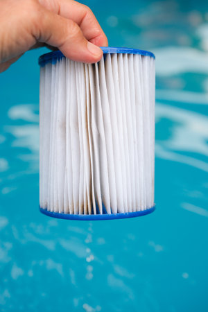 Replacement Pool Filter Cartridge in a Woman's Hand. Water Flows Down the Wet Filter. Filter Reuse.の写真素材