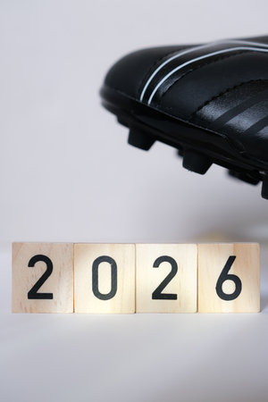 Detail of a black soccer cleat with spikes on a light, trendy background. Shallow depth of field....