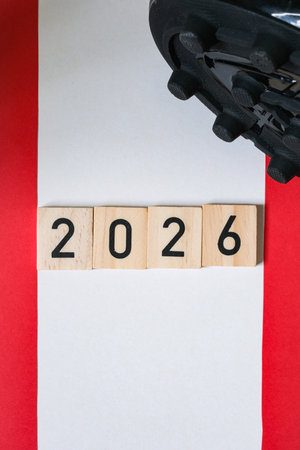Detail of a black football boots with spikes. Wooden numbers 2026. Blurred background of the...