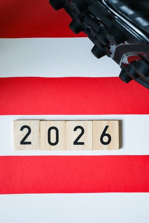 Detail of a black football boots with spikes. Wooden numbers 2026. Blurred background of the...
