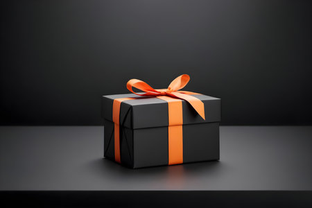 Black gift box with orange bow on black background. 3d renderの素材
