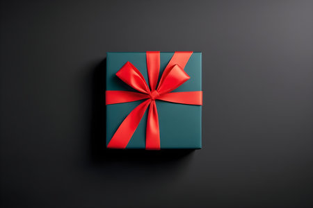 Gift box with red bow on black background. Top view.の素材