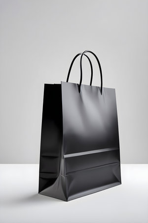 Black paper shopping bag on white background. 3d render illustration.の素材