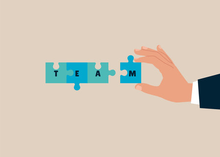 Hand holding jigsaw puzzle with a word team. Concept join our team banner, flyer, landing page or social media post.のイラスト素材