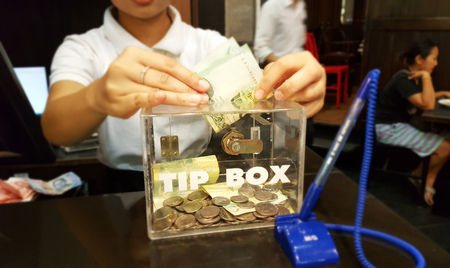 Giving money into tip box, thailand moneyのeditorial素材