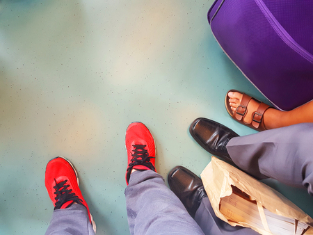 people wearing different shoes in a train