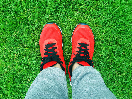 red sneakers on a background of green grassの写真素材