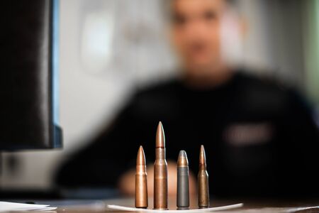 cartridges and bullets of various calibers on the table at the detective investigating the crime. training of police officers and criminologists.の写真素材