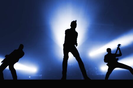 Silhouettes of cool rock band musicians on stage. outlines of popular musicians for a music festival bannerの写真素材