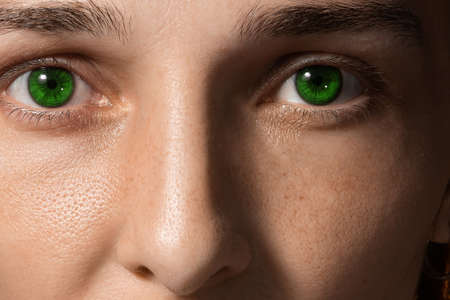 close-up face of a girl with green lenses and freckles. Girl without makeup. clean fresh skin