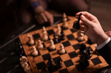 Black wooden chess bishop in the hand of a playing manの写真素材