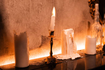 Witch candle burns in a beautiful interior for magic for halloweenの写真素材