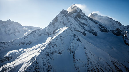 A stunning view of a snow-covered mountain peak against a clear blue sky, showcasing the beauty and grandeur of nature's landscape.の写真素材