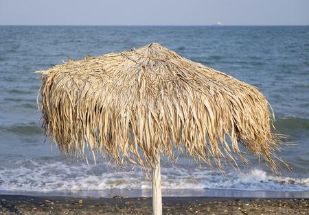 Straw umbrella on sandy beachの写真素材