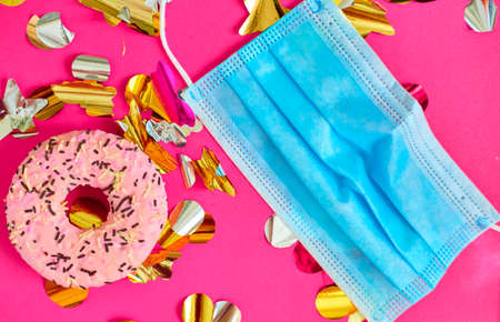 Colorful gift boxes with medical mask and donuts