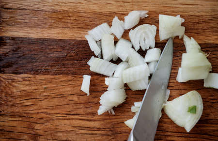 chopped onion on a board. knife with a bow. healthy food. chopped onionの写真素材