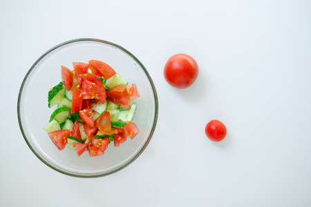 salad with vegetables. summer salad on the table. harvest on a plate. tomato and cucumber are cut into pieces.の写真素材