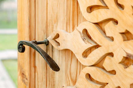 wooden sign on a wooden background. wooden gate. wood Gate with patterns. Wood decor. Iron handle on the door. Rustic style in the interiorの写真素材