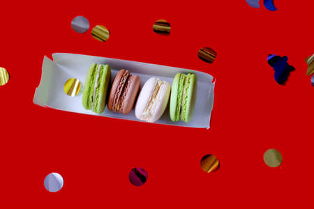 gift set. macarons in a box. assorted macaroons. Ordering desserts. Cake and glitter. Red background