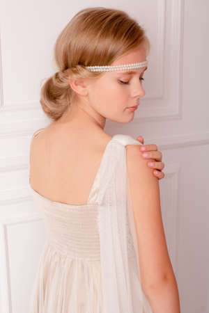 girl in the Greek style. hairstyle in the Greek style for long hair. Gentle photo of a girl. pearl headbandの写真素材