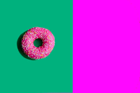 pink donut isolated on bright background. Harmful and correct food. Healthy lifestyle. Choice in nutrition. Junk food. Sweet dessertの写真素材