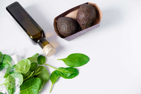 olive oil, avocado, spinach on a white plate. Still life of healthy food. Composition of products...