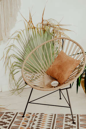 chair on the table with flowers. interior in Bali style. Wooden wicker chair. Boho style summer interiorの写真素材