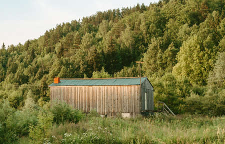 wooden house in the woods. Green forest in summer. Hermitage in nature. Forest landscape with wooden houseの写真素材