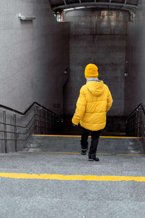 boy on the escalator in the metro. smiling child goes down the escalator in the subway. the concept of self-reliance of the childの写真素材