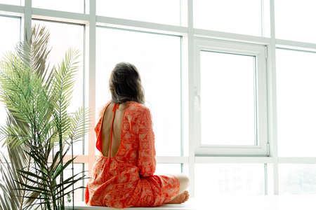 Yoga at home. Keep calm. Attractive young woman sitting on lotus position on floor with eyes closed.の写真素材