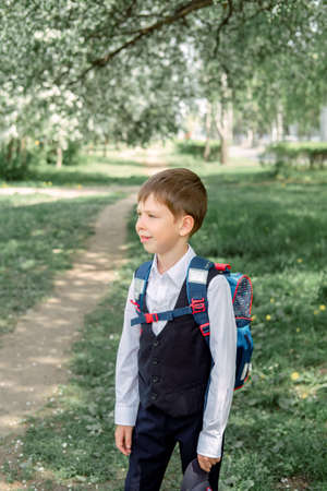 Happy boy with a backpack and a cap goes to school. The beginning of the new school year after the...