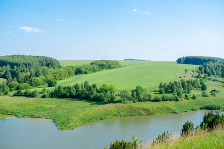 Beautiful summer landscape Forests on the hill and lakes. Summer green countryside nature landscape. The lake under the forest.の写真素材