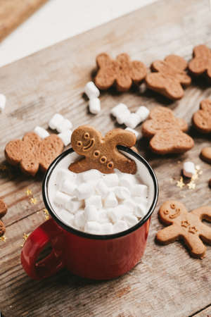 ginger man in a cup of cocoa with a big red bow on a wooden background, top view. Various Christmas sweets with a cup of cocoa on the table. Christmas flatlayの写真素材