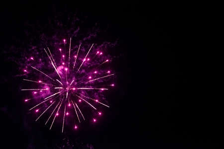 round fireworks and purple fireworks against the black sky. Christmas fireworks in the night sky. Christmas fireworks in the night skyの写真素材
