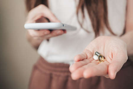Vitamins for every day and a phone in the hands of the girl. spirulina, fish oil and magnesium in...