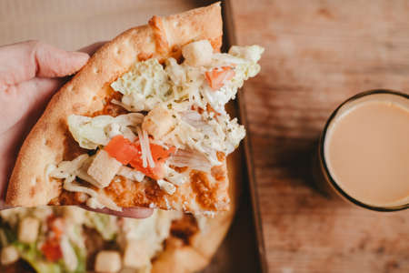 pizza caesar with chicken in handsの写真素材