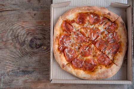 pepperoni pizza in box on wooden backgroundの写真素材