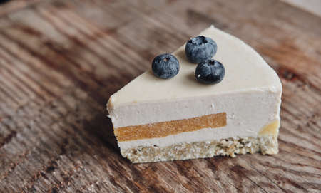 slice of gluten-free cake with sugar-free blueberries, close-up on a wooden background. Baking with...