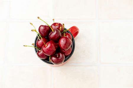 sweet cherry in a red glass on a white background top view, copy spaceの写真素材