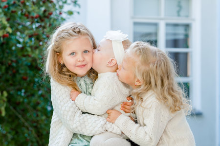 3 little girls with light hair are hugging. Love of sistersの写真素材