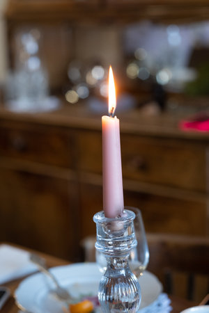 pink burning candle in a candlestick close-up.の写真素材