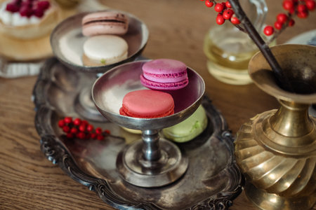 Multi-colored macaroons on an old silver dish, on the table.の写真素材