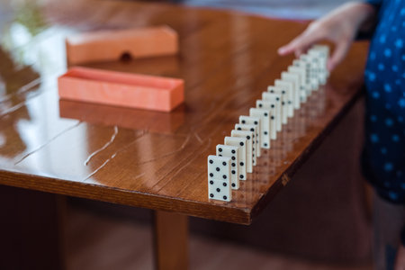 Boy playing with dominoes, close up. Build a domino fence, close upの写真素材