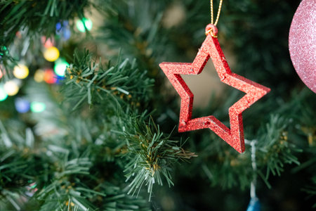 wooden Christmas tree toy in the shape of a star hanging on a branch, close-upの写真素材