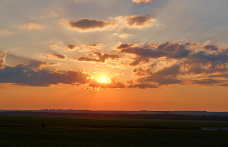 bright orange sunset covered by clouds. Fiery orange sunset sky.の写真素材
