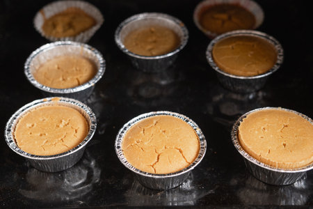 cupcakes in tins stand in the oven, close-upの写真素材
