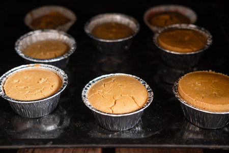 cupcakes in tins stand in the oven, close-upの写真素材