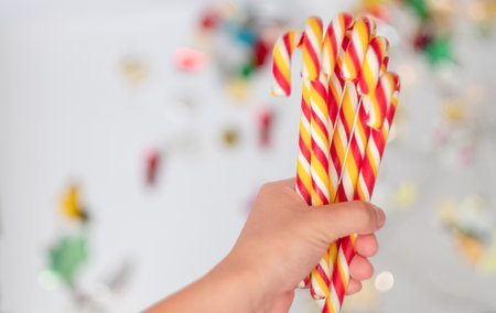 Child's hand holding Christmas candy close-up. Copyspace for text.の写真素材